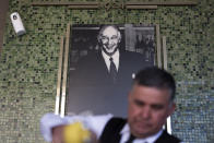 Salad Master Efrain Montoya prepares a Caesar salad in front of an image of the inventor of the salad, Caesar Cardini, at Ceasar's restaurant Thursday, June 27, 2024, in Tijuana, Mexico. Caesar salad has something to celebrate: It's turning 100. Italian immigrant Caesar Cardini is said to have invented the dish on July 4, 1924, at his restaurant, Caesar's Place, in Tijuana, Mexico. (AP Photo/Gregory Bull)