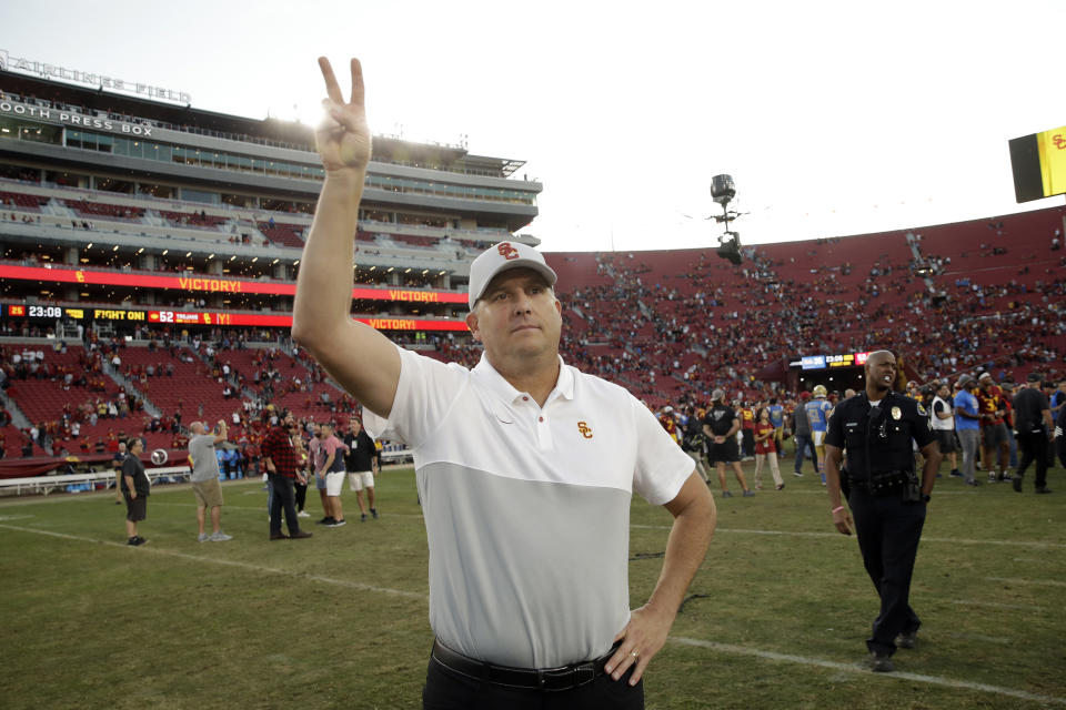 Southern California head coach Clay Helton signals to fans from midfield after a 52-35 win over UCLA on Saturday. (AP Photo/Marcio Jose Sanchez)