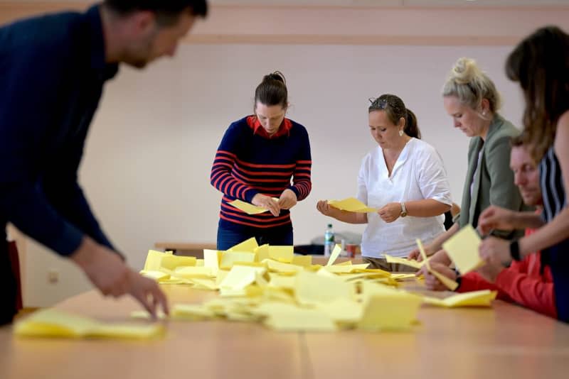 Election workers count the ballot papers for the mayoral election at the polling station in Arnstadt town hall. Jacob Schröter/dpa