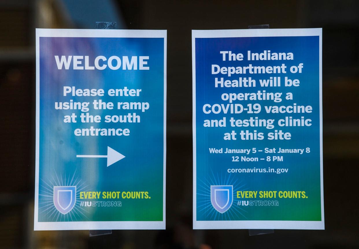 Signs  outside the COVID-19 vaccination clinic on Indiana Avenue as a car pulls up to sign in on Wednesday, Jan. 5, 2022.