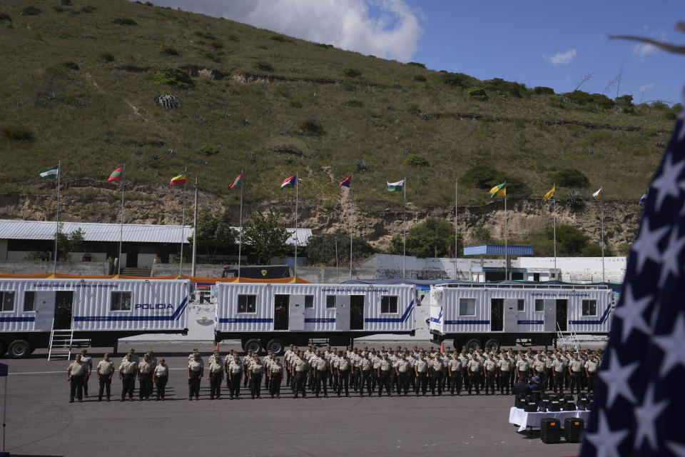 La policía ecuatoriana participa en una ceremonia en la que funcionarios de Estados Unidos entregan de unidades policiales móviles, equipadas para instalarse en la frontera, como apoyo a Ecuador en su combate contra el crimen organizado ante la espiral de violencia atribuida por las autoridades a grupos vinculados al narcotráfico, en Quito, el jueves 8 de febrero de 2024. (AP Foto/Dolores Ochoa)