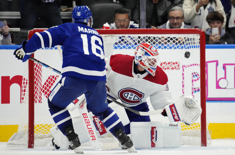 Toronto Maple Leafs' Mitchell Marner (16) scores on against Montreal Canadiens goaltender Jake Allen (34) during the shootout in an NHL hockey game Wednesday, Oct. 11, 2023, in Toronto. (Frank Gunn/The Canadian Press via AP)