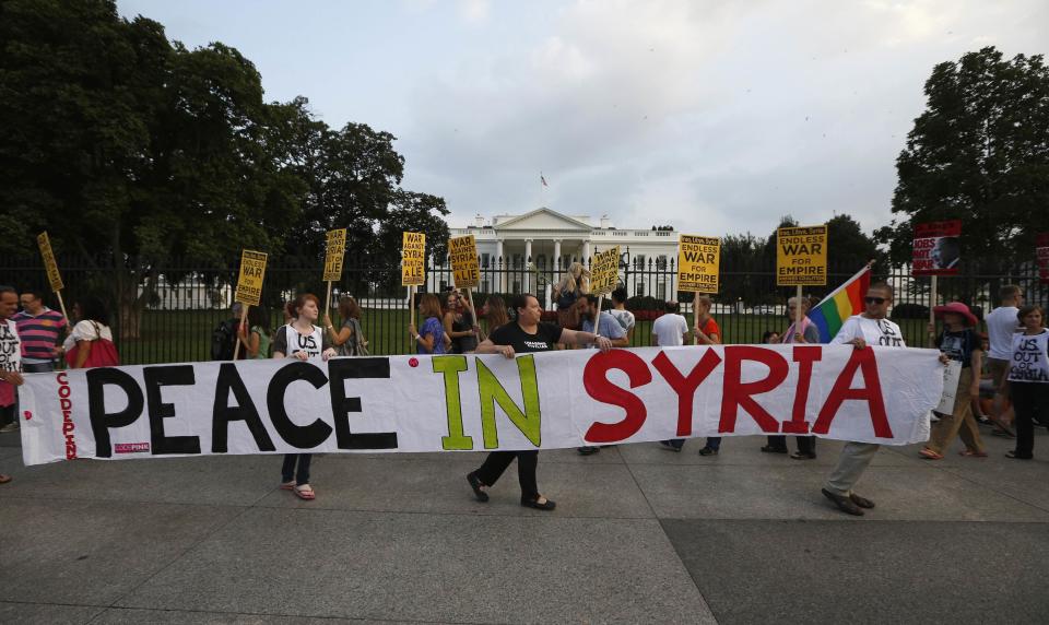 The "Act now to stop war and end racism" (ANSWER) coalition holds a banner during a rally outside the White House in Washington, August 29, 2013. The group rallied their opposition to U.S.-led military action on Syria. REUTERS/Jason Reed (UNITED STATES - Tags: POLITICS CIVIL UNREST)