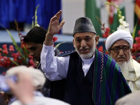 Outgoing Afghan President Hamid Karzai waves as he participates in a ceremony commemorating the 2001 assassination of legendary Tajik resistance commander Ahmad Shah Massoud, in Kabul Septembsr 9, 2014. REUTERS/Omar Sobhani