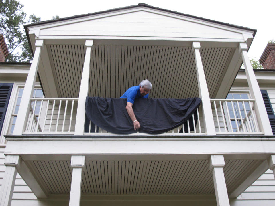 <p>Durward Matheny drapes the balcony of the Wake Forest College Birthplace in Wake Forest, N.C., in honor of alumnus Arnold Palmer on Monday, Sept. 26, 2016. Palmer attended the school and played golf there before it became moved to Winston-Salem, N.C. Palmer died Sunday, Sept. 25, 2016, in Pittsburgh. He was 87. (AP Photo/Allen G. Breed)</p>