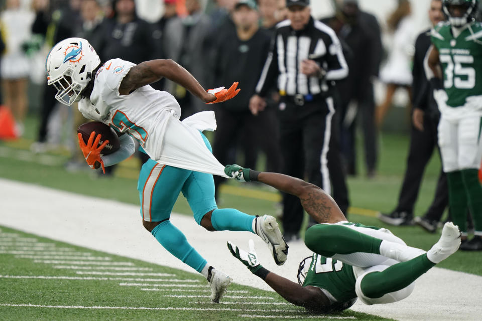 New York Jets' Quincy Williams, right, tries to bring down Miami Dolphins' Jaylen Waddle during the second half of an NFL football game, Sunday, Nov. 21, 2021, in East Rutherford, N.J. (AP Photo/Corey Sipkin)
