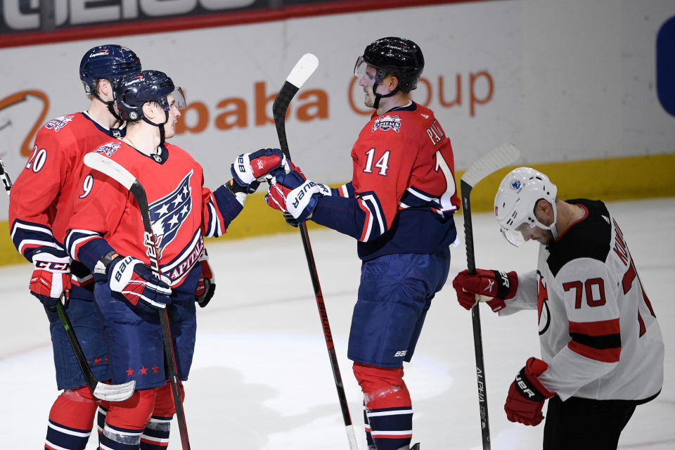 Washington Capitals defenseman Dmitry Orlov (9) celebrates his goal with right wing Richard Panik (14) and center Lars Eller (20) during the second period of an NHL hockey game, as New Jersey Devils defenseman Dmitry Kulikov (70) skates by, Tuesday, March 9, 2021, in Washington. (AP Photo/Nick Wass)