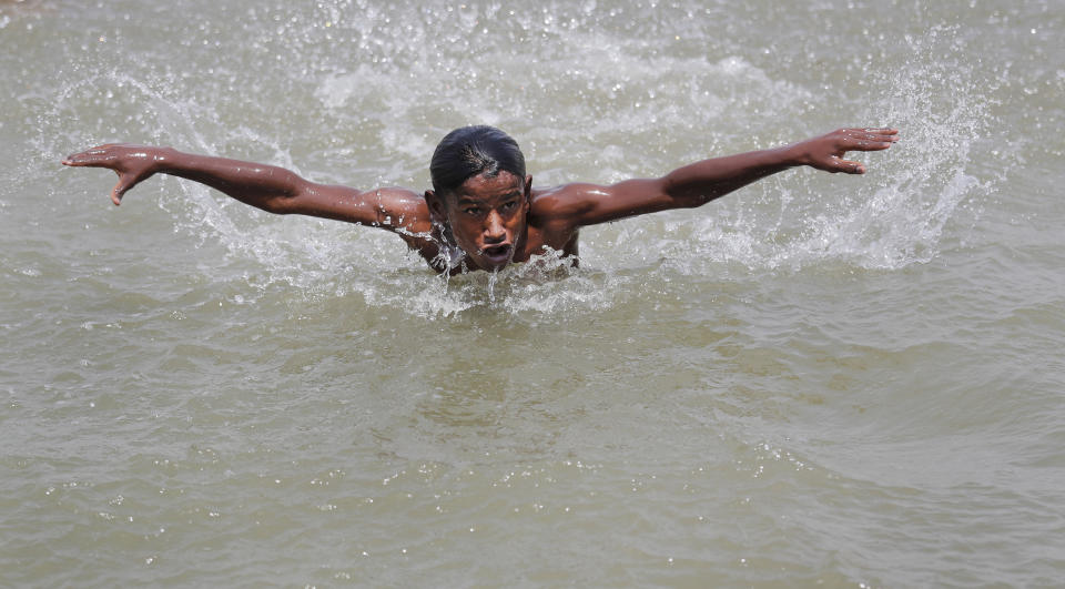 Un niño nada en el río Yamuna de Nueva Delhi el 28 de mayo del 2020, en medio de una ola de calor infernal que se suma al coronavirus y a una invasión de langostas que azotan la India. (AP Photo/Manish Swarup)