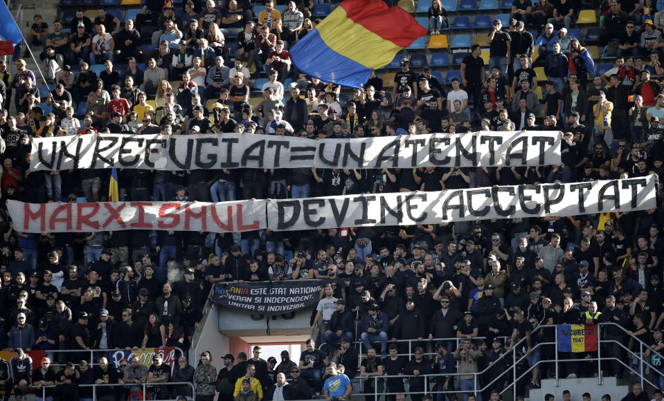 Romanian fans hold banners that read "One refugee equals one terror attack - Marxism becomes acceptable" during the UEFA Nations League soccer match between Romania and Serbia on the National Arena stadium in Bucharest, Romania, Sunday, Oct. 14, 2018. (AP Photo/Vadim Ghirda)