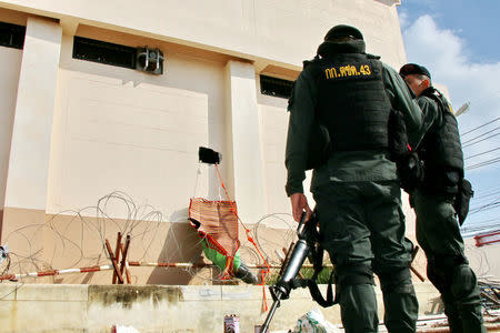 Military officers stand next to a square hole in the wall of a detention center near the Thailand-Malaysia border in Hatyai, Songkla, Thailand, November 20, 2017. Picture taken November 20, 2017. Dailynews/ via REUTERS