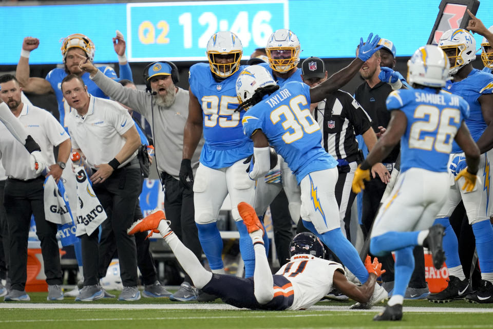 Los Angeles Chargers cornerback Ja'Sir Taylor, center, is pushed out of bounds by Chicago Bears wide receiver Darnell Mooney after an interception during the first half of an NFL football game Sunday, Oct. 29, 2023, in Inglewood, Calif. (AP Photo/Ashley Landis)