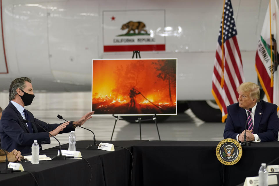 El presidente Donald Trump escucha al gobernador Gavin Newsom informarle sobre los incendios que afectan a California, el lunes 14 de septiembre de 2020 en el aeropuerto McClellan de Sacramento, en McClellan Park, California. (AP Foto/Andrew Harnik)