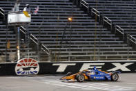 Scott Dixon earns the checkered flag as he crosses the finish line to win an IndyCar auto race at Texas Motor Speedway in Fort Worth, Texas, Saturday, June 6, 2020. (AP Photo/Tony Gutierrez)