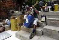 Nicolás Gómez, artista del reciclaje, comprueba las cuerdas de un violonchelo hecho con un barril de petróleo de la Orquesta de Instrumentos Reciclados de Cateura.