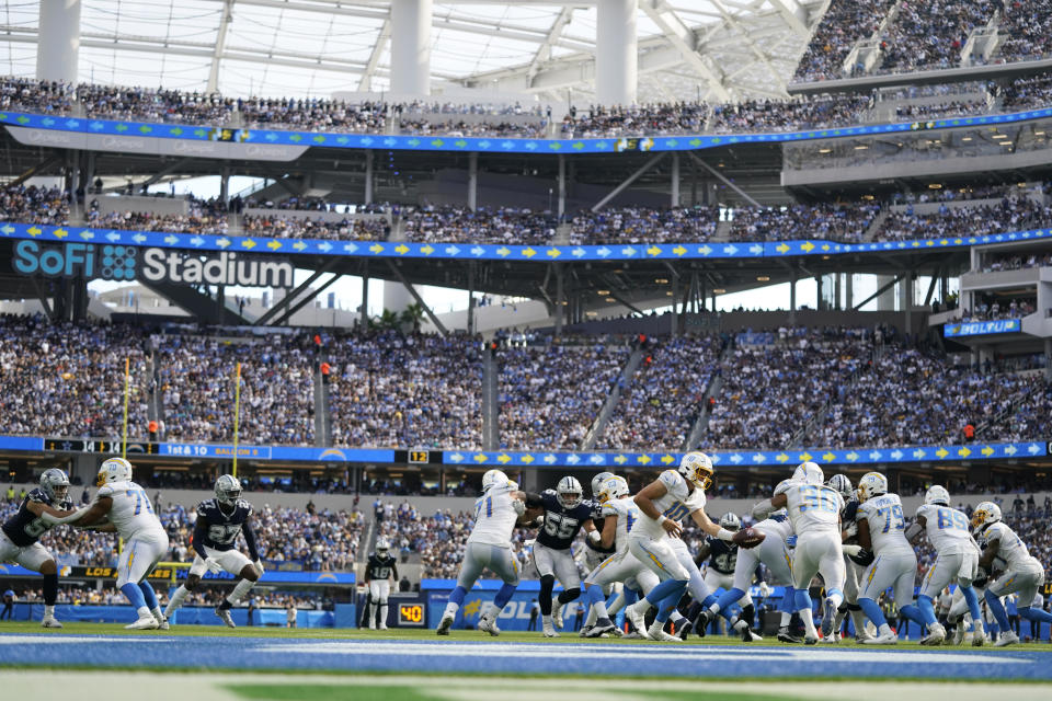 Los Angeles Chargers quarterback Justin Herbert hands off to running back Austin Ekeler (30) during the second half of an NFL football game Sunday, Sept. 19, 2021, in Inglewood, Calif. (AP Photo/Ashley Landis)