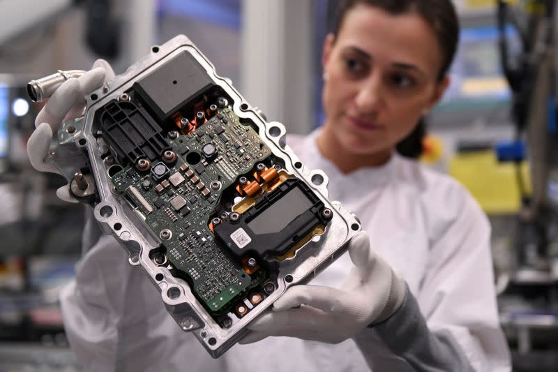 FILE PHOTO: Employee of German car parts maker Continental inspects a power electronics component at the factory of the company's Powertrain unit in Nuremberg