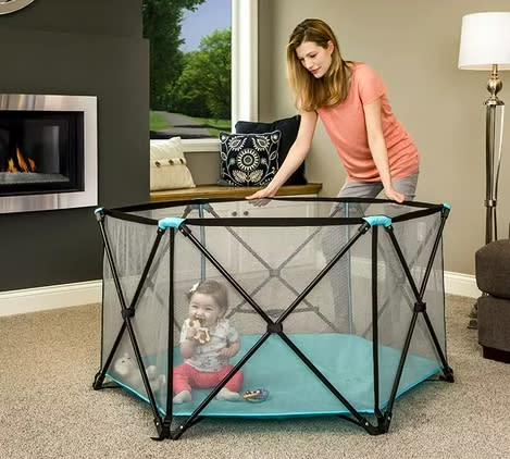 The play yard with a baby inside in a living room