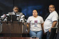 Lawyer Shaka Johnson, from left, Zoraida Garcia, the aunt, and Eddie Irizarry, the father, watch video footage of the death of Eddie Irizarry during a press conference, in Philadelphia, Tuesday, Aug. 22, 2023. Irizarry is the 27-year-old man shot and killed by a Philadelphia police officer. (Jessica Griffin/The Philadelphia Inquirer via AP)