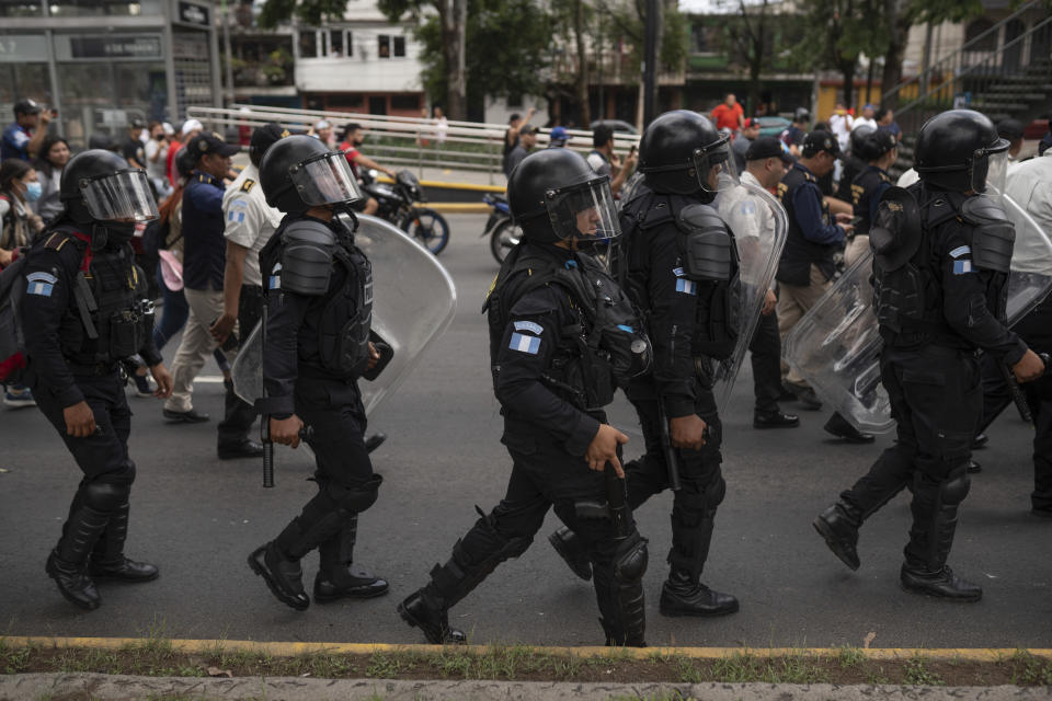 Police in riot gear march on a highway blocked by demonstrators during a national strike, in Guatemala City, Tuesday, Oct. 10, 2023. People are protesting to support President-elect Bernardo Arévalo after Guatemala's highest court upheld a move by prosecutors to suspend his political party over alleged voter registration fraud. (AP Photo/Santiago Billy)
