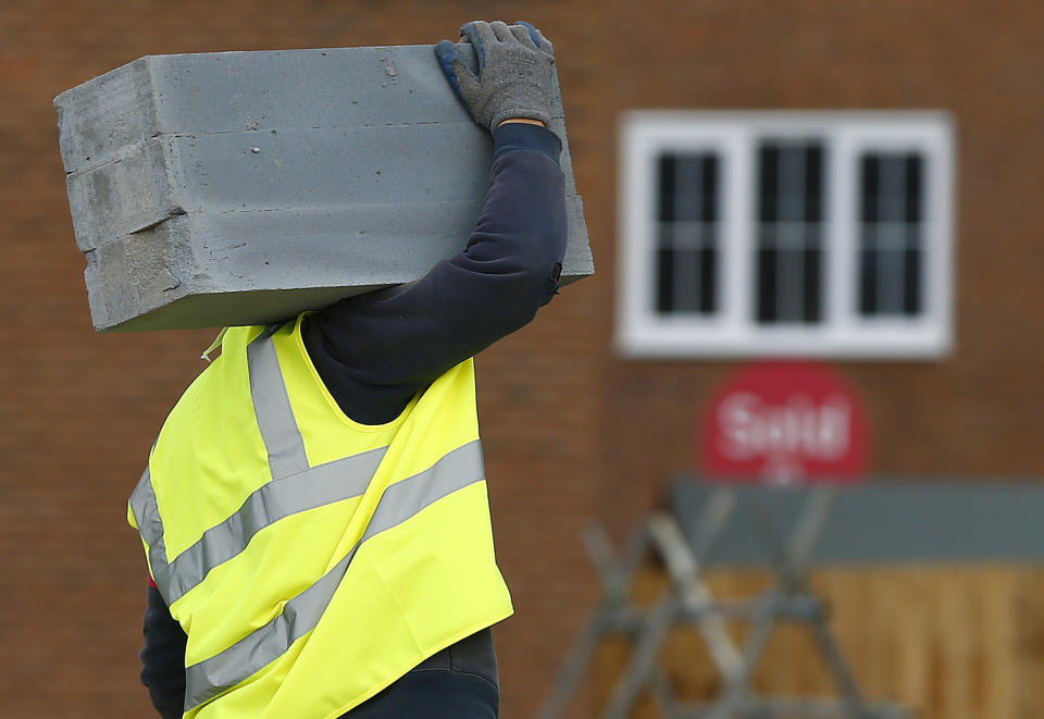 A builder carries blocks on a Barratt Homes building site in Nuneaton, central England March 20, 2014. REUTERS/Darren Staples   (BRITAIN)