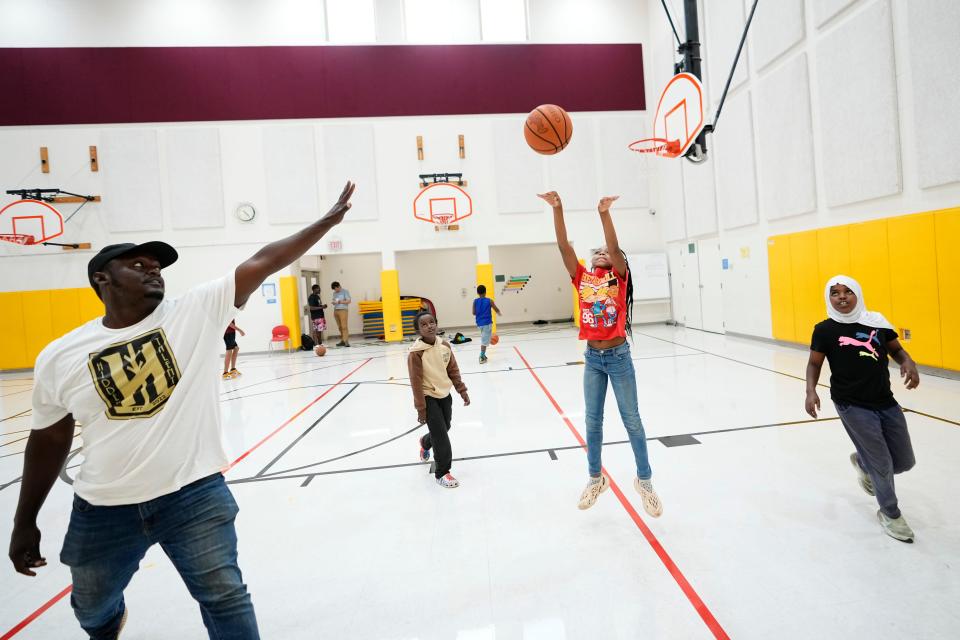 Aa’layiah Love, 10, shoots over coach Aden Mohamed during a Neighborhood Athletics basketball practice Tuesday at Sullivant Elementary on the West Side.