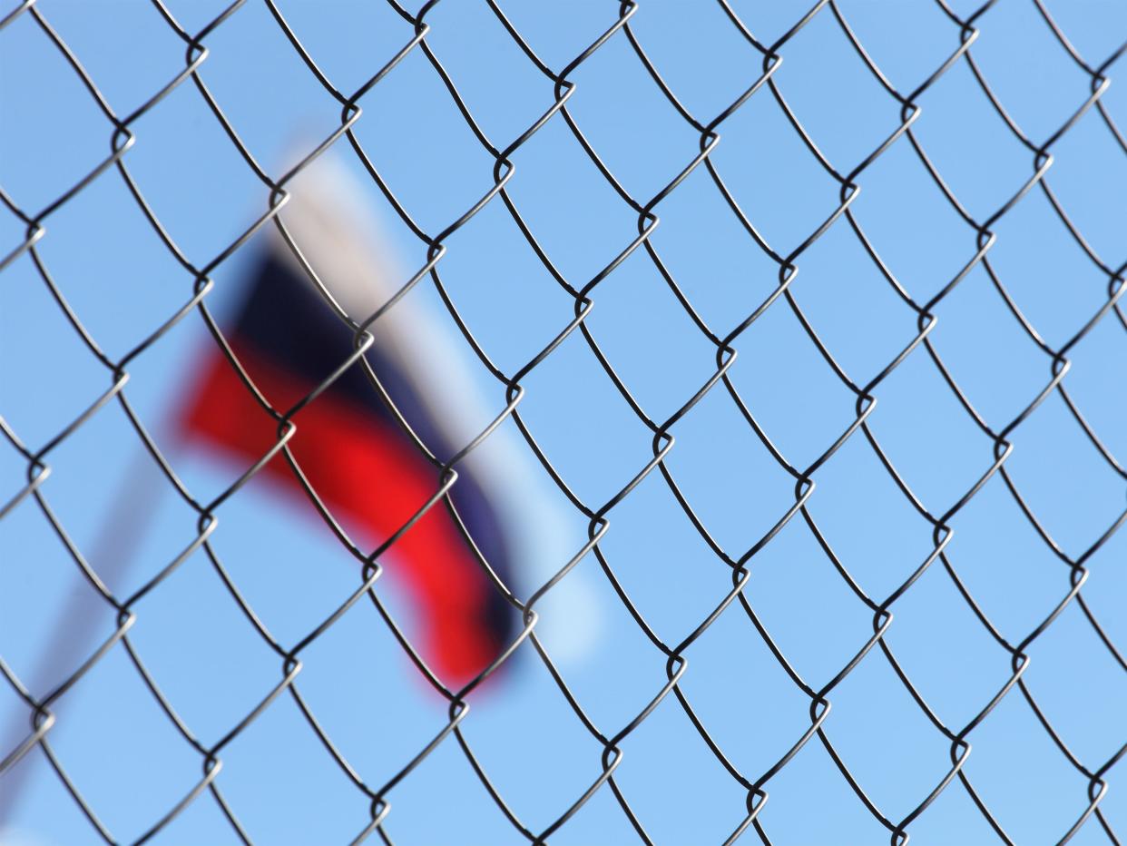 Russian flag behind a fence.