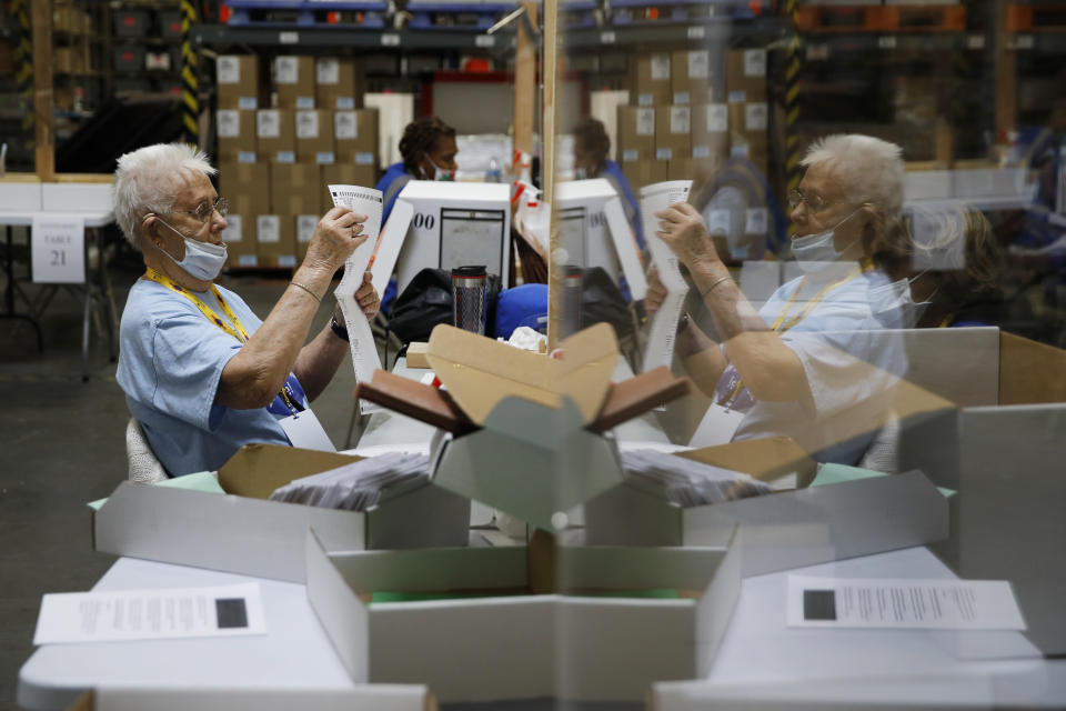 FILE - In this June 9, 2020, file photo, election workers process mail-in ballots during a nearly all-mail primary election in Las Vegas. A surge of absentee ballots during last year's election led to concerns that a larger percentage of mailed ballots could be rejected for arriving past the deadline, not having a voter's signature or some other reason. An analysis by The Associated Press shows that didn't happen. (AP Photo/John Locher, File)