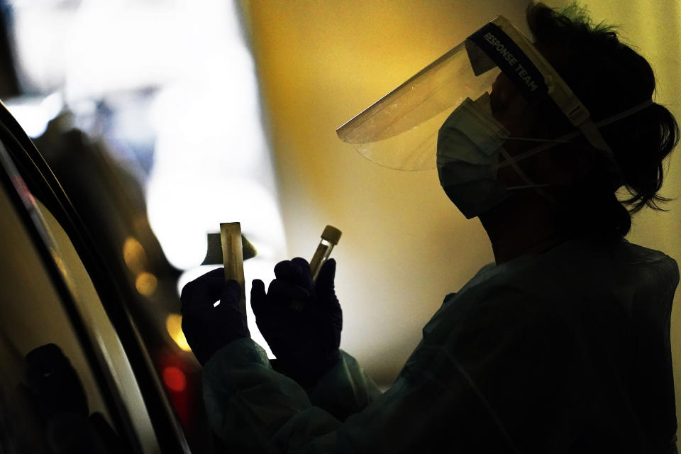 A tester wears personal protective equipment as she speaks with a patient at a mobile testing location for COVID-19, Tuesday, Dec. 8, 2020, in Auburn, Maine. More than 14,000 Mainers have been diagnosed with the disease and 239 have died. (AP Photo/Robert F. Bukaty)