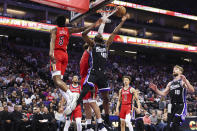 New Orleans Pelicans guard Herbert Jones (5) defends against a shot by Sacramento Kings forward Harrison Barnes (40) during the first half of an NBA basketball game Thursday, April 11, 2024, in Sacramento, Calif. (AP Photo/Benjamin Fanjoy)