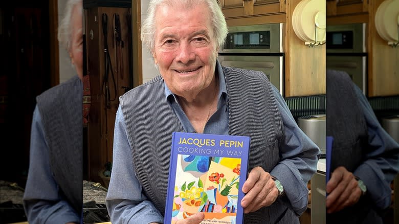 Jacques Pépin smiling and holding Cooking My Way