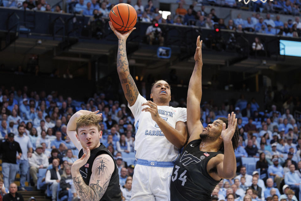 North Carolina's Armando Bacot (5) attempts a shot between Virginia Tech's Mylyjael Poteat (34) and Tyler Nickel, left, during the first half of an NCAA college basketball game in Chapel Hill, N.C., Saturday, Feb. 17, 2024. (AP Photo/Ben McKeown)