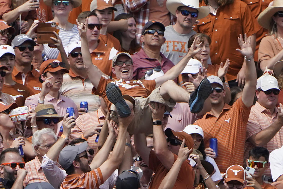 FILE - A Texas fan crowd surfs in the the second half of an NCAA college football game between Oklahoma and Texas at the Cotton Bowl in Dallas, Saturday, Oct. 8, 2022. The Big 12 is losing its marquee matchup when the Red River Rivalry is played Saturday for the final time under the league’s umbrella. (AP Photo/LM Otero, File)