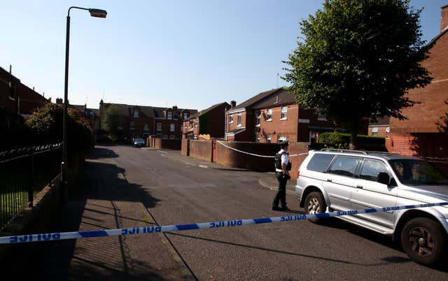 The Short Strand area in Belfast showing a police officer next to a silver car behind police tape