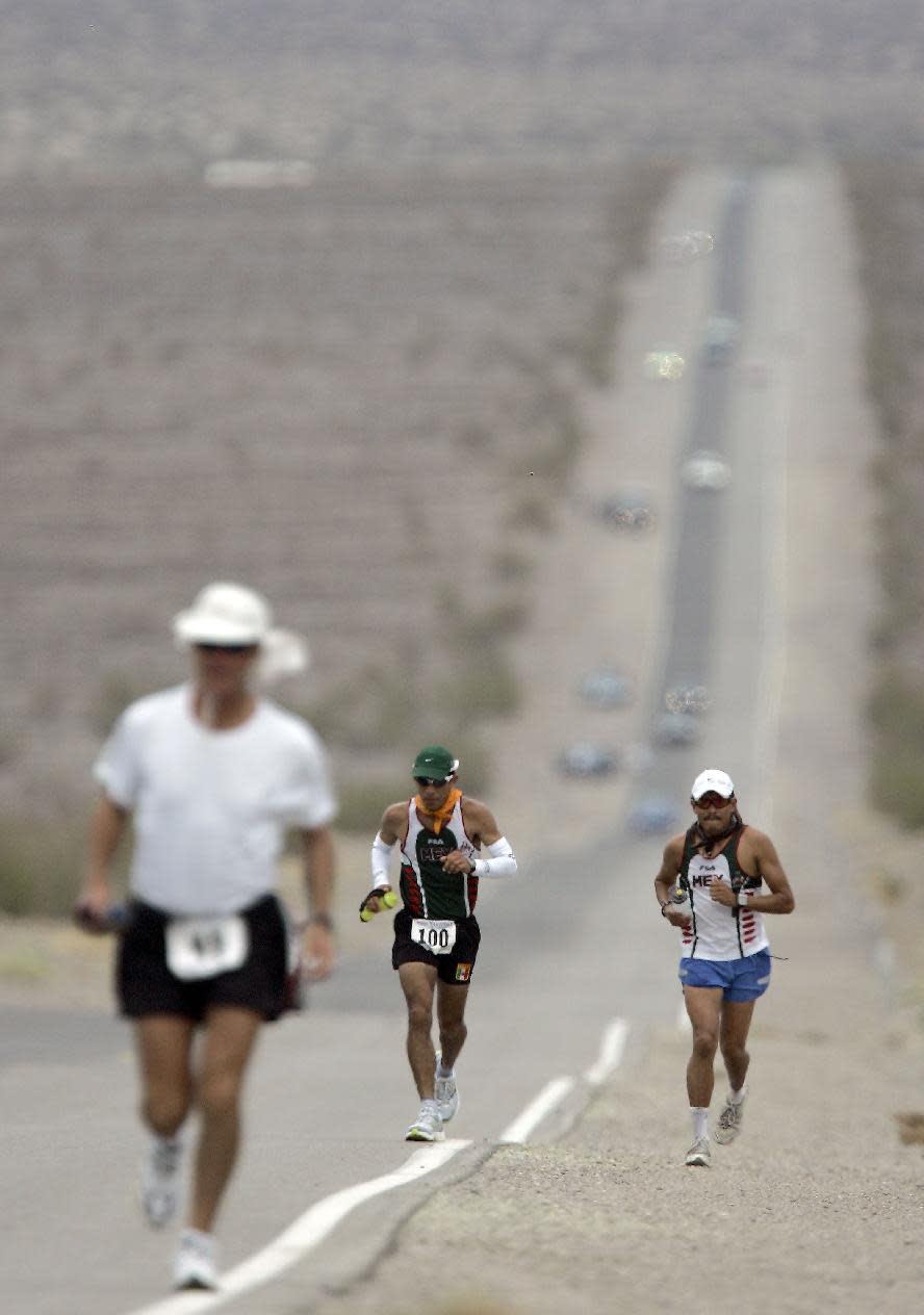 FILE - In this July 23, 2007 file photo, Jorge Pacheco, center, of Mexico, runs in Kiehl's Badwater Ultramarathon in Death Valley, Calif. The race start line wa at Badwater, Death Valley, which marks the lowest elevation in the Western Hemisphere at 280 feetbelow sea level. The race finished after 135 miles at the Mount Whitney Portals at 8,360 feet. Death Valley National Park is putting the brakes on ultramarathons and other extreme sports events that involve running and cycling until rangers can determine how safe it is to hold those competitions in a place that records the hottest temperatures on Earth. (AP Photo/Chris Carlson, File)