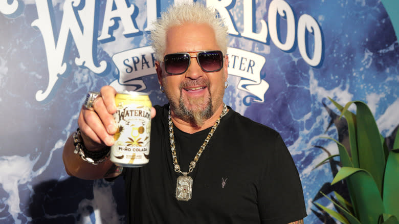 Guy Fieri holds up a can of water