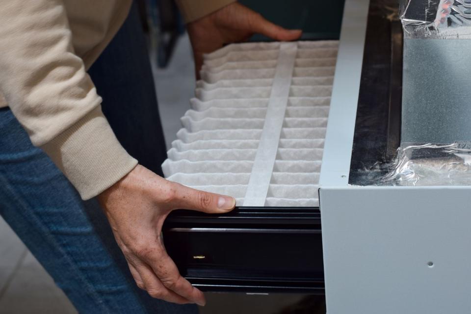 A close up of someone taking apart a furnace. 