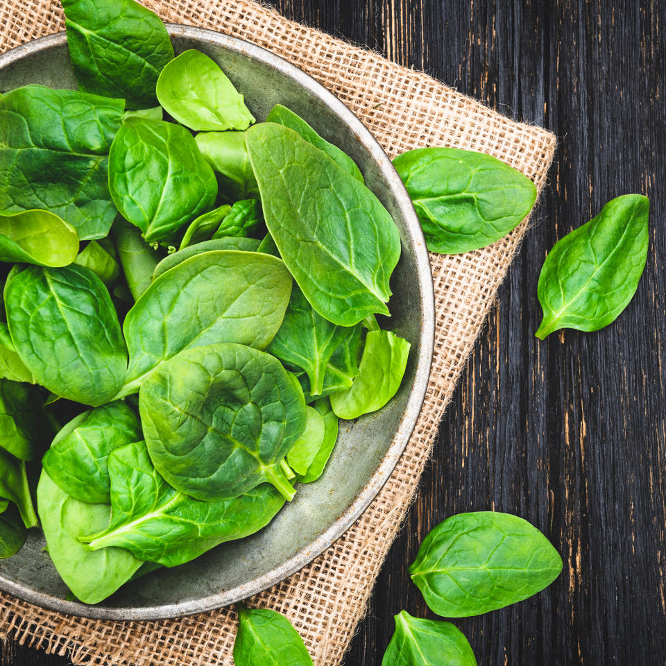 Bowl of spinach on wooden table