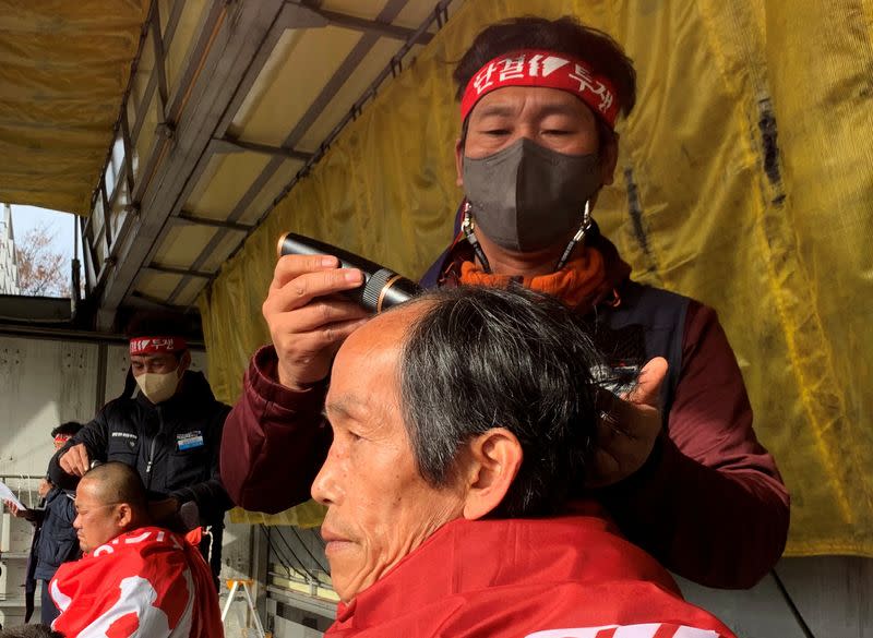 Unionised truck drivers have their hair shaved at a head-shaving protest in Uiwang