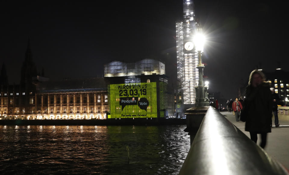 A projection calling for a second referendum or a so-called "Peoples's vote", on behalf of a pressure group, is cast onto the Houses of Parliament in London, Wednesday Feb. 27, 2019. British Prime Minister Theresa May says she will give British lawmakers a choice of approving her divorce agreement, leaving the EU March 29 without a deal or asking to delay Brexit by up to three months. (AP Photo/Alastair Grant)