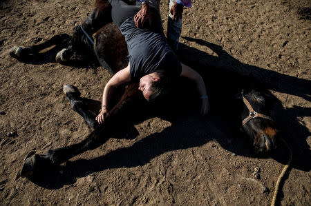 Fernando Noailles, emotional therapist, and his patient Maria Lopez Herraiz attend an emotional therapy session with a horse named Madrid in Guadalix de la Sierra, outside Madrid, Spain, April 27, 2018. REUTERS/Juan Medina