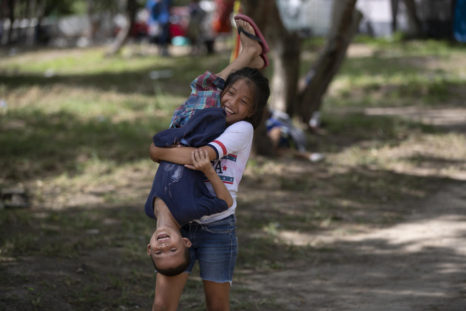 In this Oct. 11, 2019 photo, migrant children play in an area where other migrants set up camp near a legal port of entry bridge in Matamoros, Mexico. In years past, migrants seeking asylum in the United States moved quickly through this violent territory on their way to the U.S., but now due to Trump administration policies, they remain here for weeks and sometimes months as they await their U.S. court dates, often in the hands of gangsters who hold Tamaulipas state in a vice-like grip. (AP Photo/Fernando Llano)