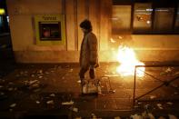 A woman passes by a Bankia bank branch during a protest in Madrid November 4, 2013. Spain's labor unions called for an indefinite strike from Tuesday in Spain's capital for the street cleaning and park maintenance sectors in protest against announced layoffs that could affect around a thousand municipal workers, according to local media. (REUTERS/Juan Medina)