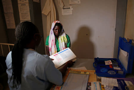 A nurse from Marie Stopes NGO chats with a woman at a dispensary in the village of Nedgo, near Ouagadougou, Burkina Faso February 16, 2018. REUTERS/Luc Gnago