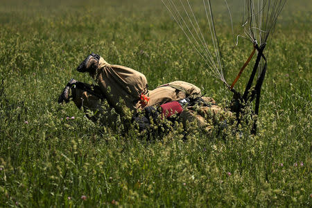 A smokejumper recruit lands after leaping from an airplane during a training exercise in a field adjacent to the North Cascades Smokejumper Base in Winthrop, Washington, U.S., June 7, 2016. REUTERS/David Ryder