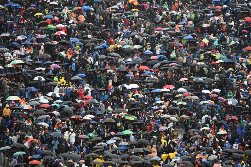 Umbrellas go up as the rain comes down (Photo by OLI SCARFF/AFP/Getty Images)