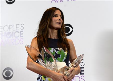 Sandra Bullock poses with the awards she won for favorite movie actress, favorite comedic movie actress and favorite dramatic movie actress at the 2014 People's Choice Awards in Los Angeles, California January 8, 2014. REUTERS/Kevork Djansezian