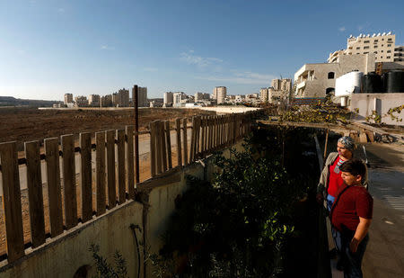 Haya Khader, a Palestinian teacher from East Jerusalem, stands outside the building she lives in, in Kfar Aqab on the outskirts of Jerusalem, near the West Bank City of Ramallah, November 7, 2017. Picture taken November 7, 2017. REUTERS/Mohamad Torokman