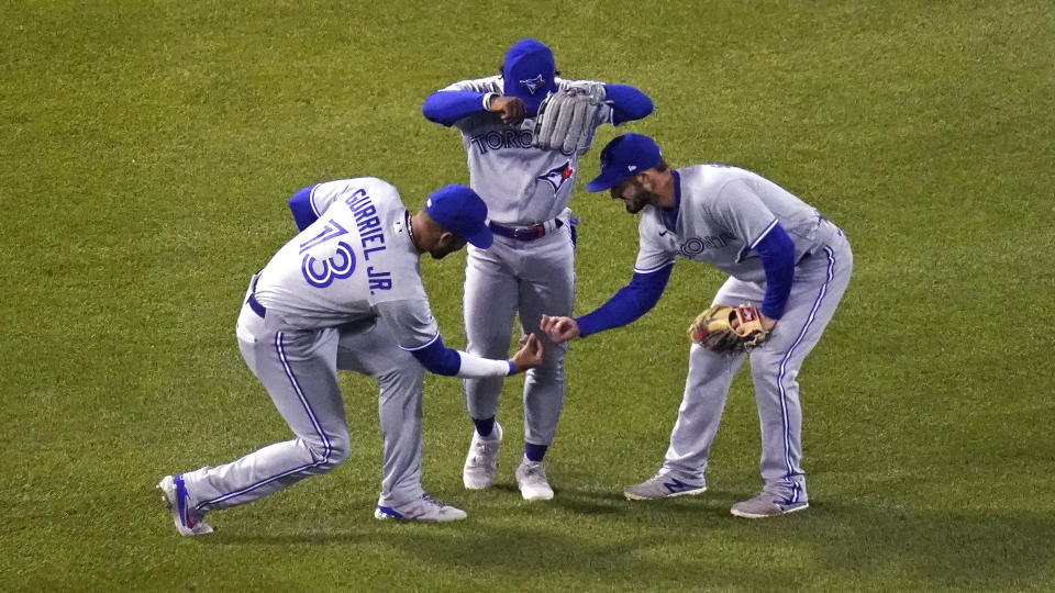 Toronto Blue Jays outfielders Lourdes Gurriel Jr., Jonathan Davis and Randal Grichuk, from left, celebrate after the Blue Jays defeated the Boston Red Sox 6-3 in a baseball game at Fenway Park, Wednesday, April 21, 2021, in Boston. (AP Photo/Charles Krupa)