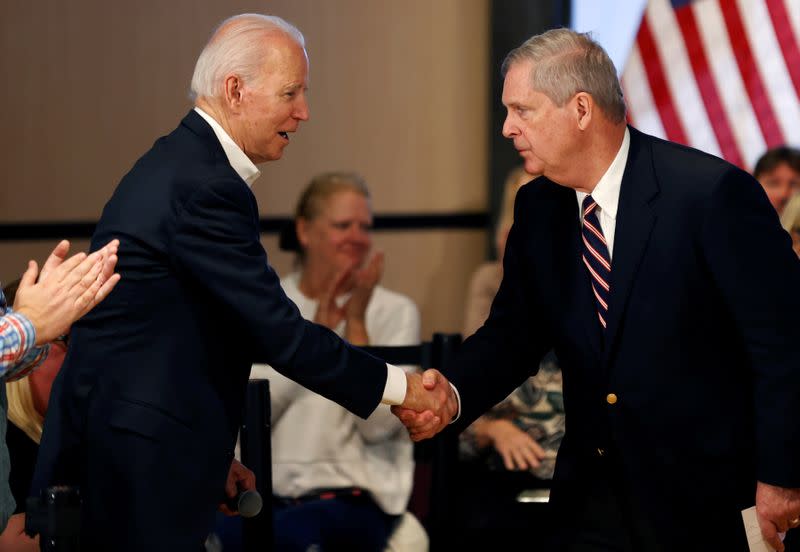FILE PHOTO: Democratic 2020 U.S. presidential candidate and former Vice President Joe Biden shakes hands with former Iowa Governor Tom Vilsack during a campaign event in Newton