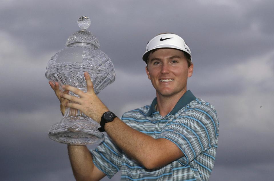 Russell Henley holds up his trophy after winning the Honda Classic golf tournament on Sunday, March 2, 2014, in Palm Beach Gardens, Fla. (AP Photo/Wilfredo Lee)